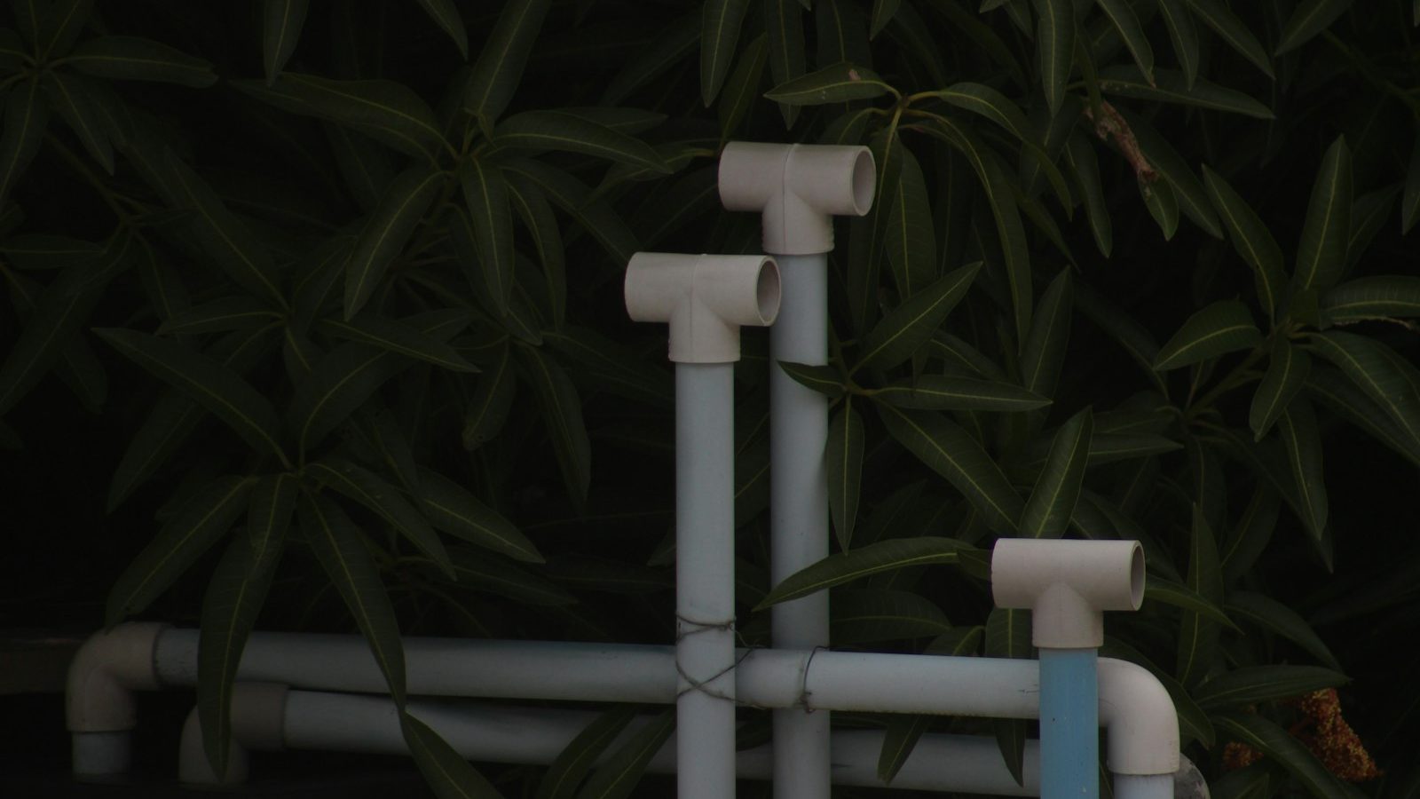 White PVC pipework and fittings installed outdoors