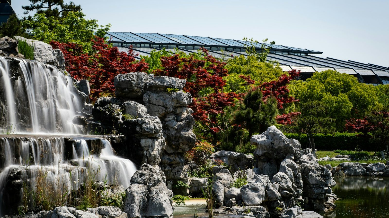 Tall rock waterfall in a landscaped garden