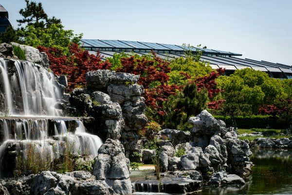 Tall rock waterfall in a landscaped garden